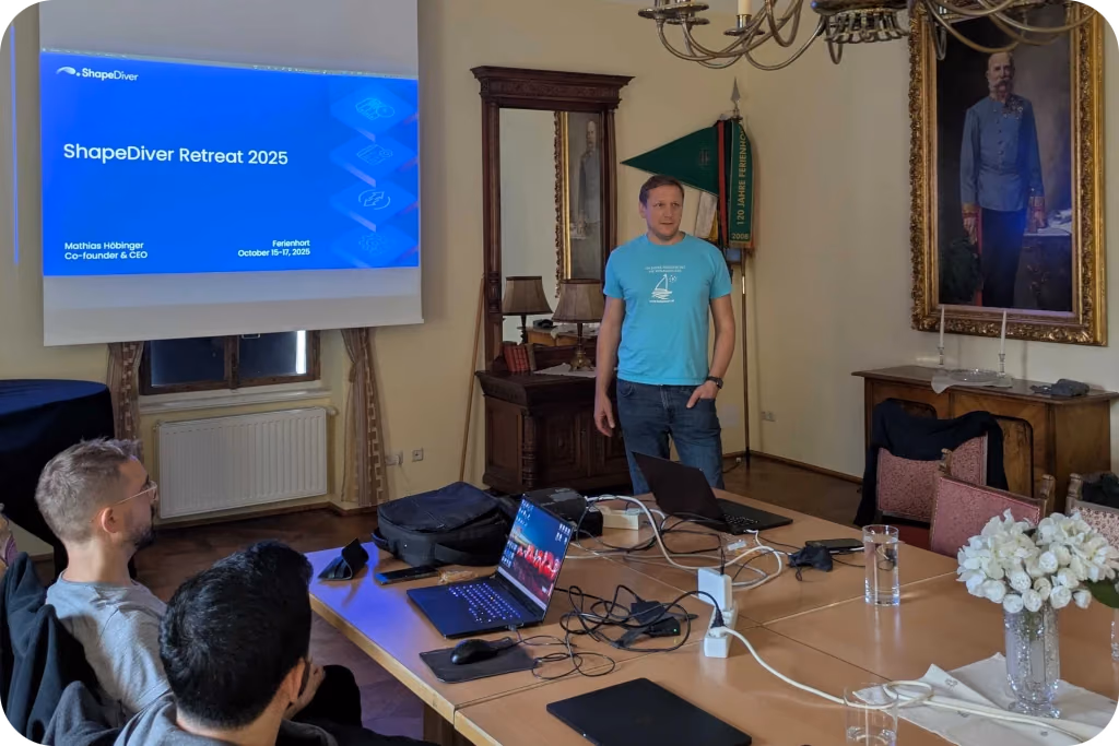 Mathias presenting to the team under a portrait of the Emperor at the 2025 retreat